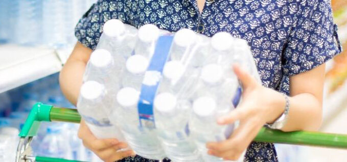 Woman holding bottles wrapped with collation shrink