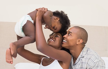 Mother and father holding baby in diaper