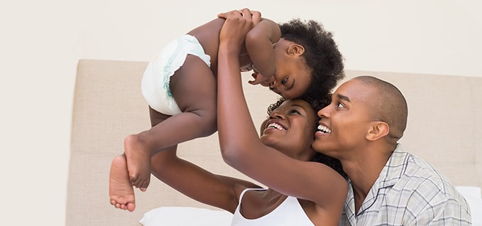 Mother and father holding baby in diaper