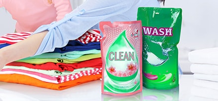 Mom and Child doing laundry with liquid packaging detergent