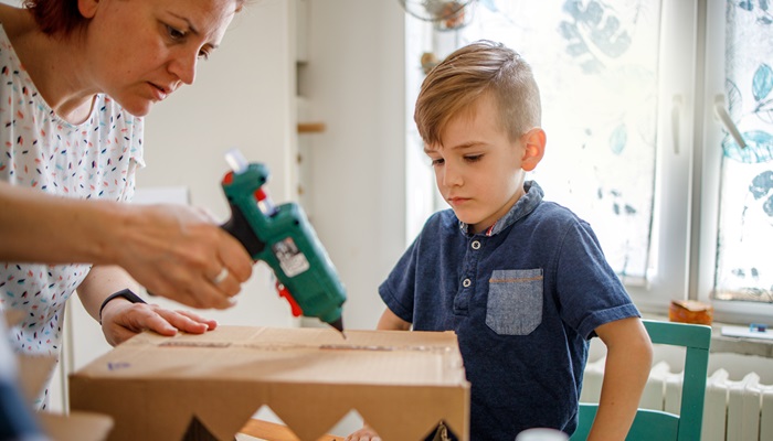 Imagen de una madre y un niño pegando una caja que muestra la función de adhesión para Vistamaxx